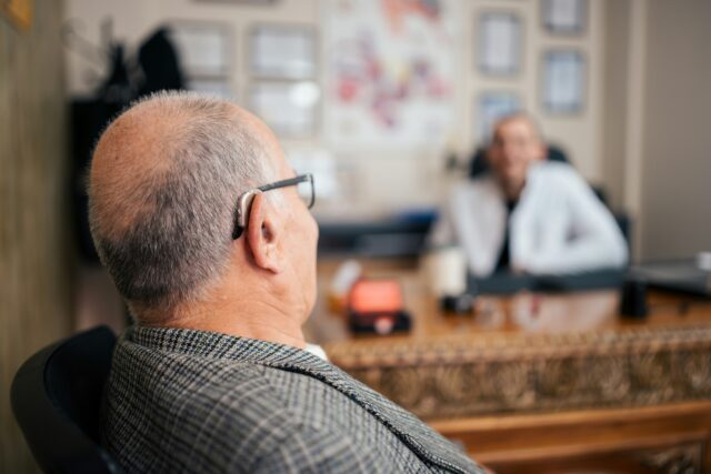 Elderly man with hearing aids